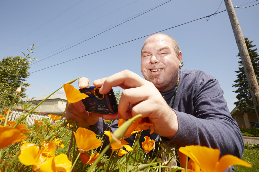 man takes photo of flowers
